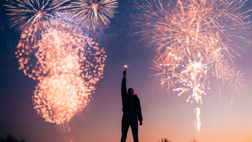 Beautiful Fireworks in Night Sky and Lone Man