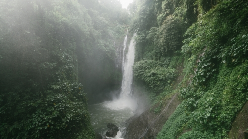 Beautiful Waterfall in Green Forest and Fog