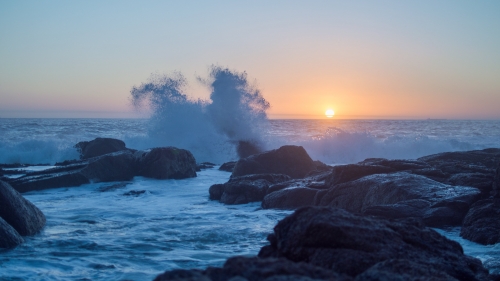 Scenic View of Rocky Shore Waves and Sunset