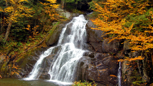 Waterfall in Rocks and Autumn Trees Around